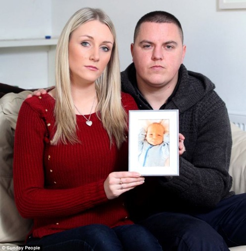 Devastated Danielle Gatehouse and Lee Pascoe hold a picture of their son Harley, at their home in Fraddon, Cornwall