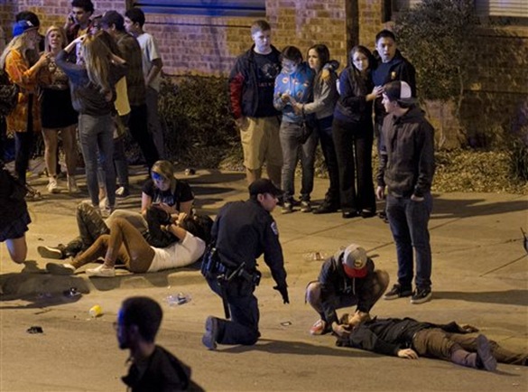 A bystander and a police officer tend to a man who was struck by a vehicle on Red River Street in downtown Austin, Texas, at SXSW on Wednesday March 12, 2014