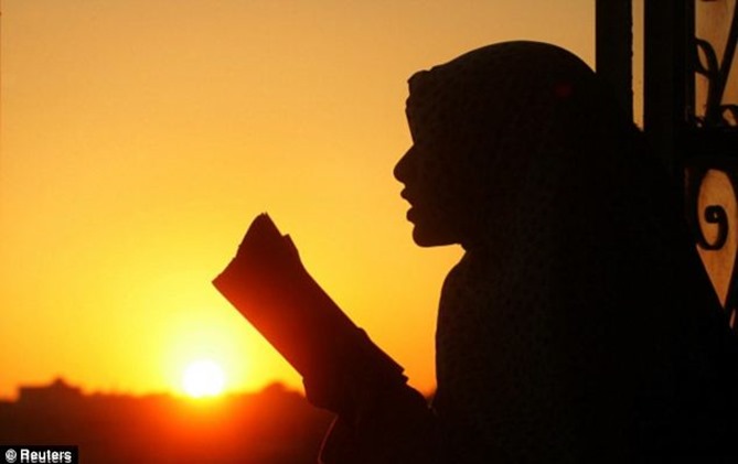 Ramadan requires Muslims to fast during daylight hours - so they will be at their hungriest towards the end of the day. Above, a girl reads from the Koran on the last Friday of the holy period in the Islamic calendar