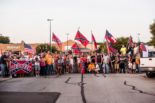 A group gathers for a photo during a confederate flag rally that ended in a parking lot in Knoxville, Tennessee after motorcading through the city on Thursday, July 17, 2015. Host Tom Pierce, and guest, Mathew Heimbach delivered speeches at the meeting place in Seymour, Tennessee before prompting the group to drive through the city with flags raised. Mike Belleme for Al Jazeera America 